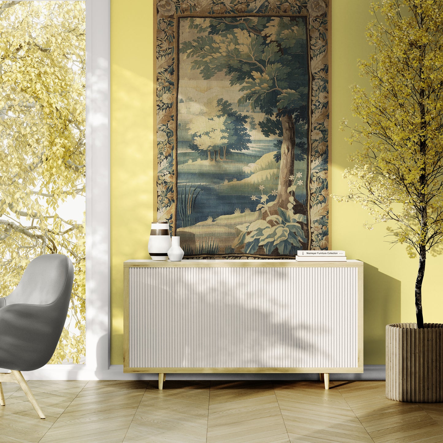 A modern white ribbed sideboard cabinet with gold legs, styled in a bright room with a large framed landscape tapestry on the wall, a gray chair, and a potted tree.
