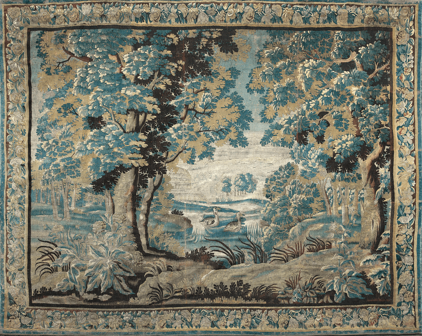 A tapestry featuring a serene woodland scene with trees, a stream, and what appears to be a pair of swans in the foreground. The background suggests a landscape with hills and a sky.