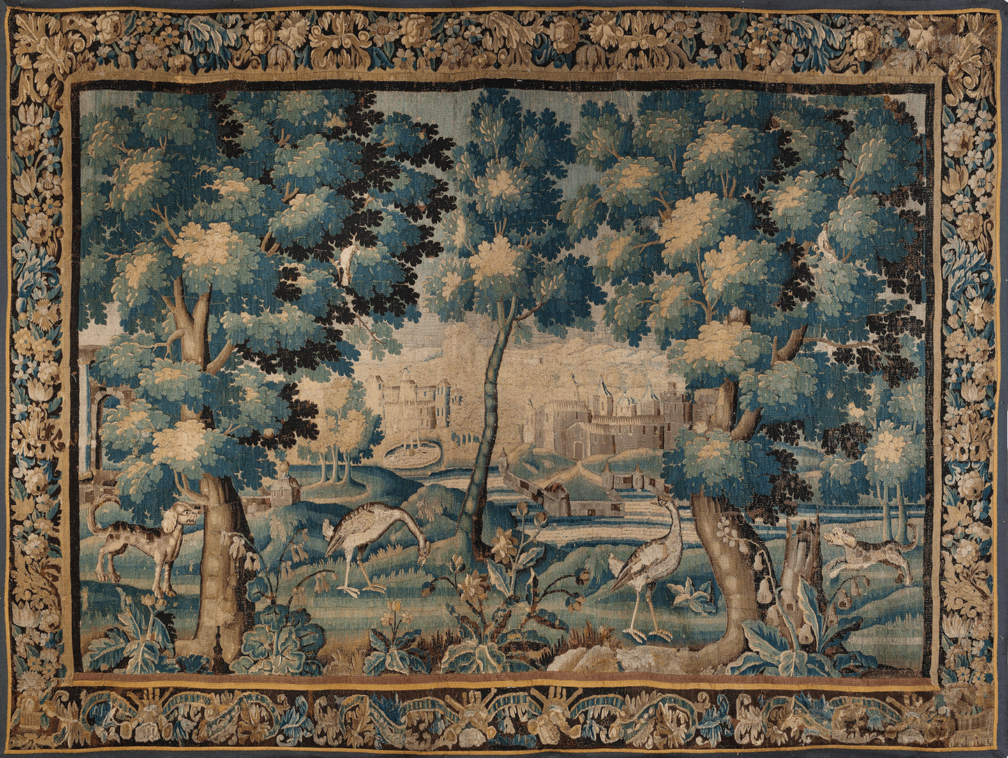 This exquisite verdure tapestry is a masterful reproduction inspired by the lush landscapes of the 17th century Flemish tradition. The scene features a serene woodland landscape populated with detailed foliage, elegant trees, and graceful birds, all woven with a palette of verdant greens, soft blues, and earthy browns. The background showcases a distant castle, blending nature and architecture in a harmonious tableau. This tapestry is a superb example of the verdure style, characterized by its emphasis on n