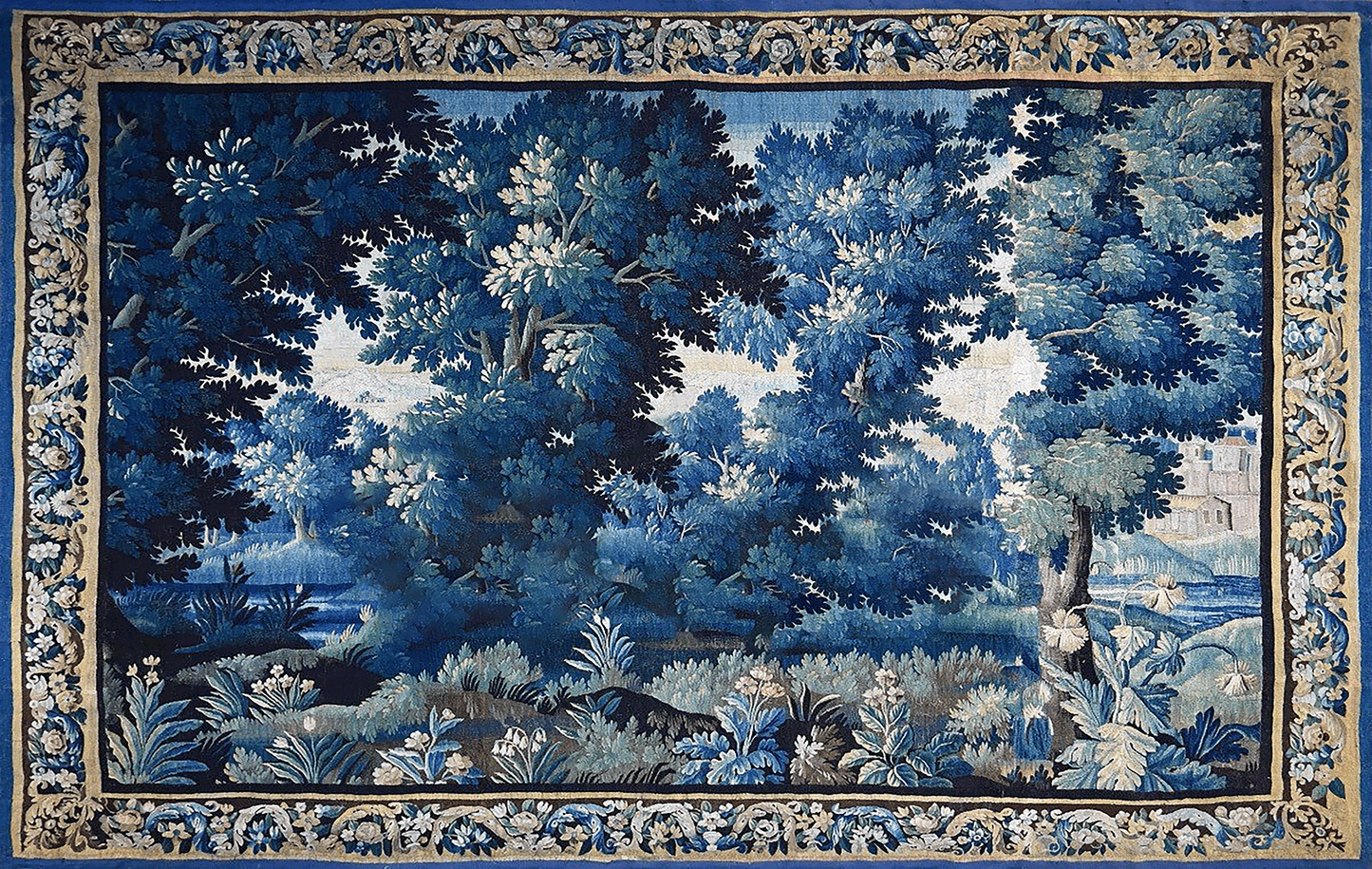 A square woven tapestry featuring a detailed blue and white forest landscape with trees, foliage, and a decorative floral border around the edges.