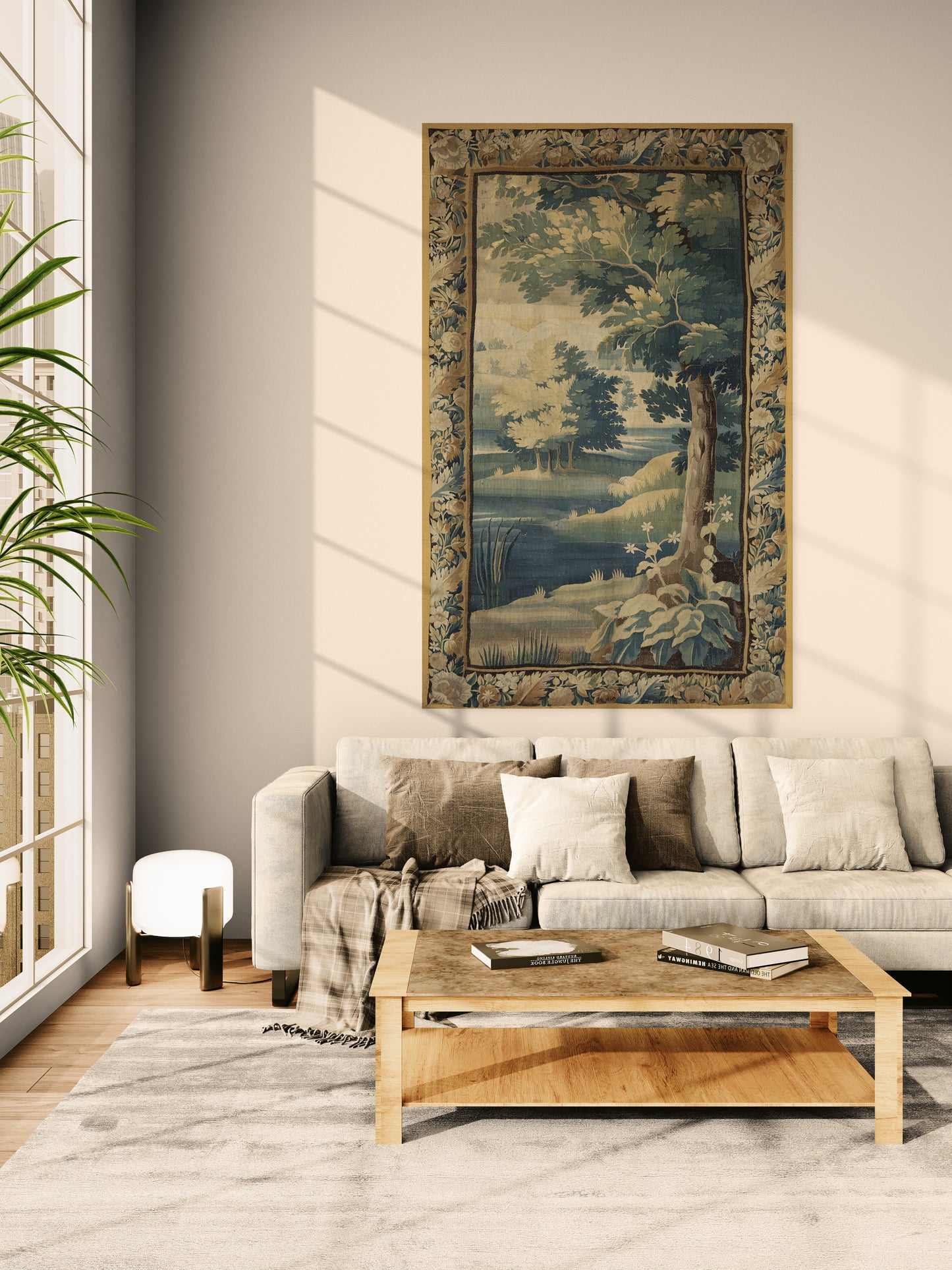 A large framed landscape tapestry with a detailed tree and river scene hangs on a beige wall above a light gray sofa in a modern living room setting.