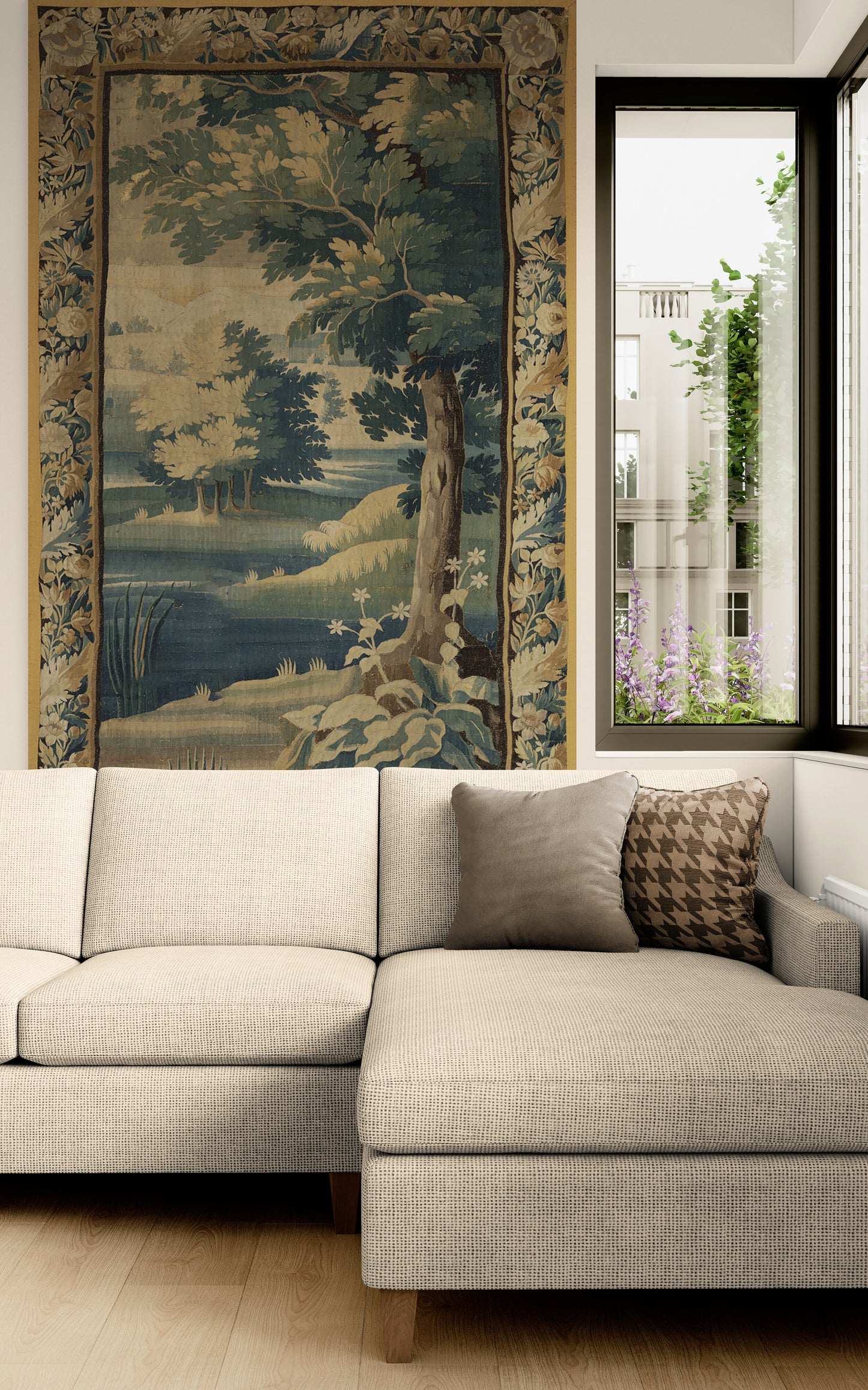 A large tapestry featuring a classical landscape scene with trees, water, and a river, hung on a wall above a light beige sectional sofa in a modern living room setting.