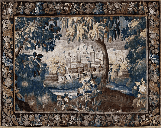 An ornate rectangular tapestry featuring a detailed landscape scene with a grand chateau, trees, water, and figures in the foreground, surrounded by a decorative floral border.