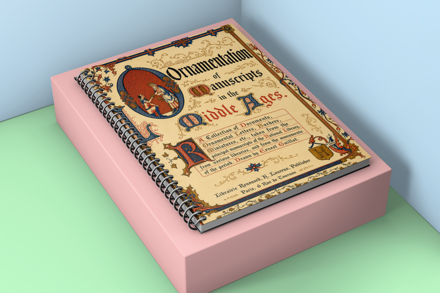 A spiral-bound book titled "Ornamentation of Manuscripts in the Middle Ages" displayed on a pink rectangular block against a light blue and mint green background.