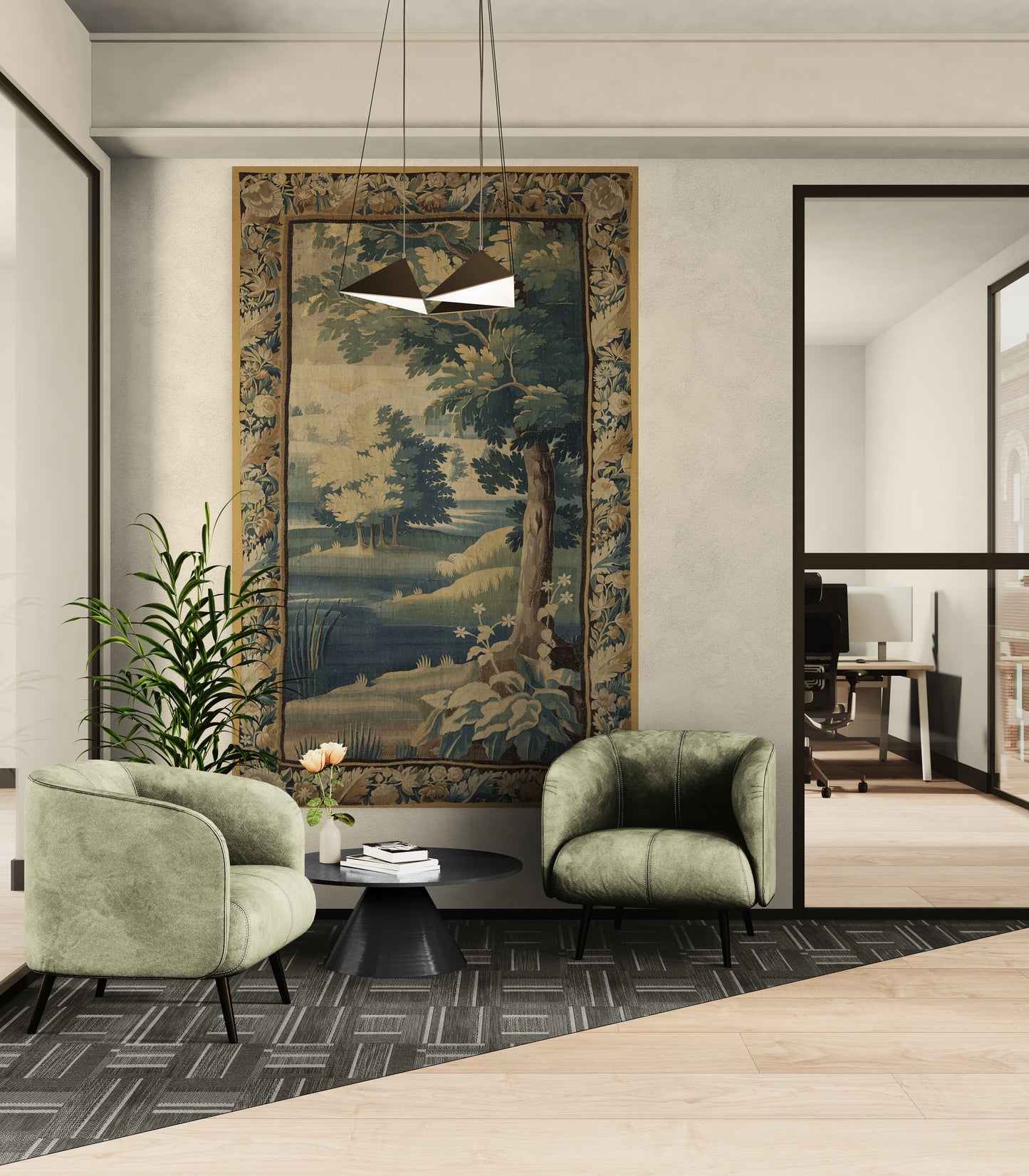 A large framed landscape tapestry with a golden-brown border hangs on a light gray wall in a modern office lobby. The room features two green velvet armchairs, a small black coffee table with flowers, a potted plant, and a geometric dark gray rug.