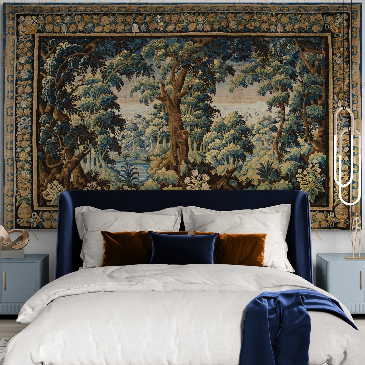 Bedroom with a large tapestry featuring a forest scene above a bed with white bedding and blue headboard.